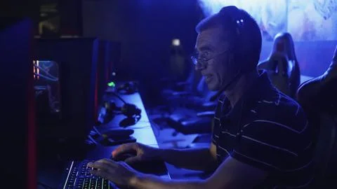 Old man playing on computer late at night in Modern computer club. Foto stock