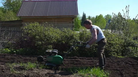 Old man plows the ground with a motor cultivator. 스톡 동영상 133221276