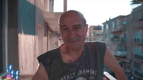 An old man posing to camera on live broadcasting, hand waving Stock Footage 122135127