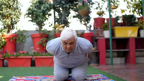 An old man is practicing Vajrasana pose on a mat - healthy lifestyle, persona... Stock Footage 233880888