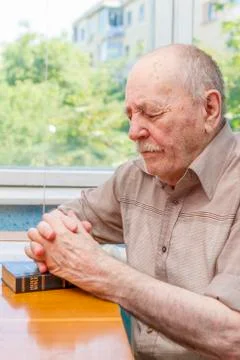 Old man praying Stockfoto's