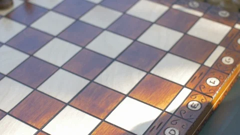 Old man prepares the chess game outside in the garden at the table and puts the Stock Footage 118713748