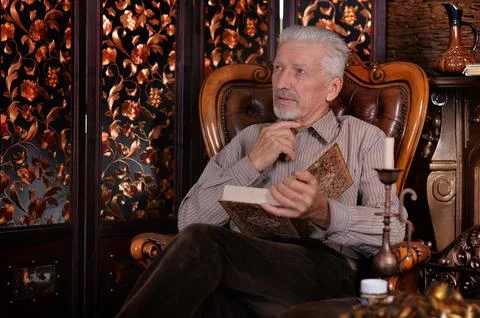 Old man preparing dinner in kitchen Stock Photos