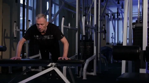 An old man pushes himself off the bench at the gym .Copy space. Stock Footage 115247881