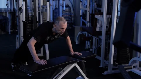Old man pushes himself off the bench at the gym .Copy space.side view Stock Footage 115853075