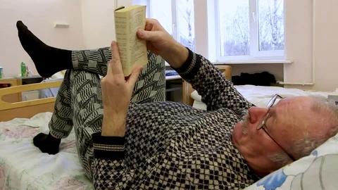 Old man read book in hosp bed Video stock 81836652
