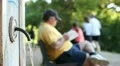 Old man readind at park (out of focus on background) HD Footage