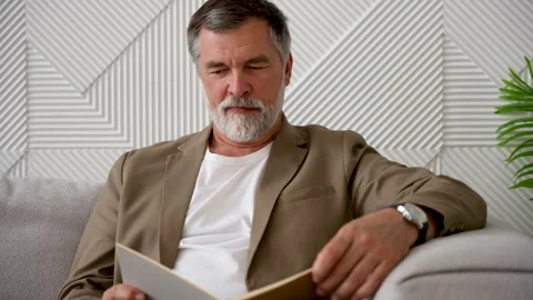 An old man reading a book in his peaceful home Stock Footage 278980325