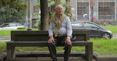 Old man rests on a bench in the city Video stock 298975199