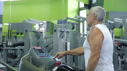 Old man runs on a treadmill Stock Footage 71637565