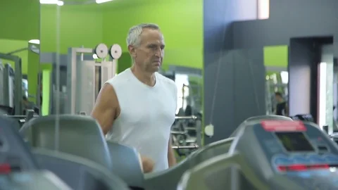 Old man runs on a treadmill Stock Footage 71638439
