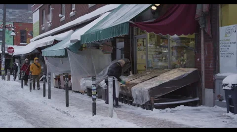 Old man scrubbing plastic sheets at shop exterior on winter day Vidéo 57068035