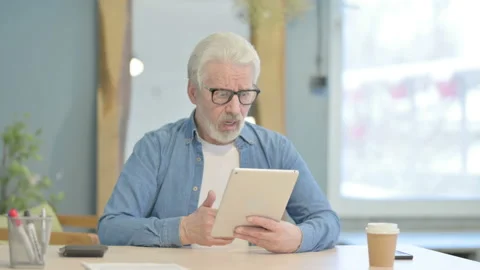 Old Man Shocked by Loss on Digital Tablet Stock Footage 230534383