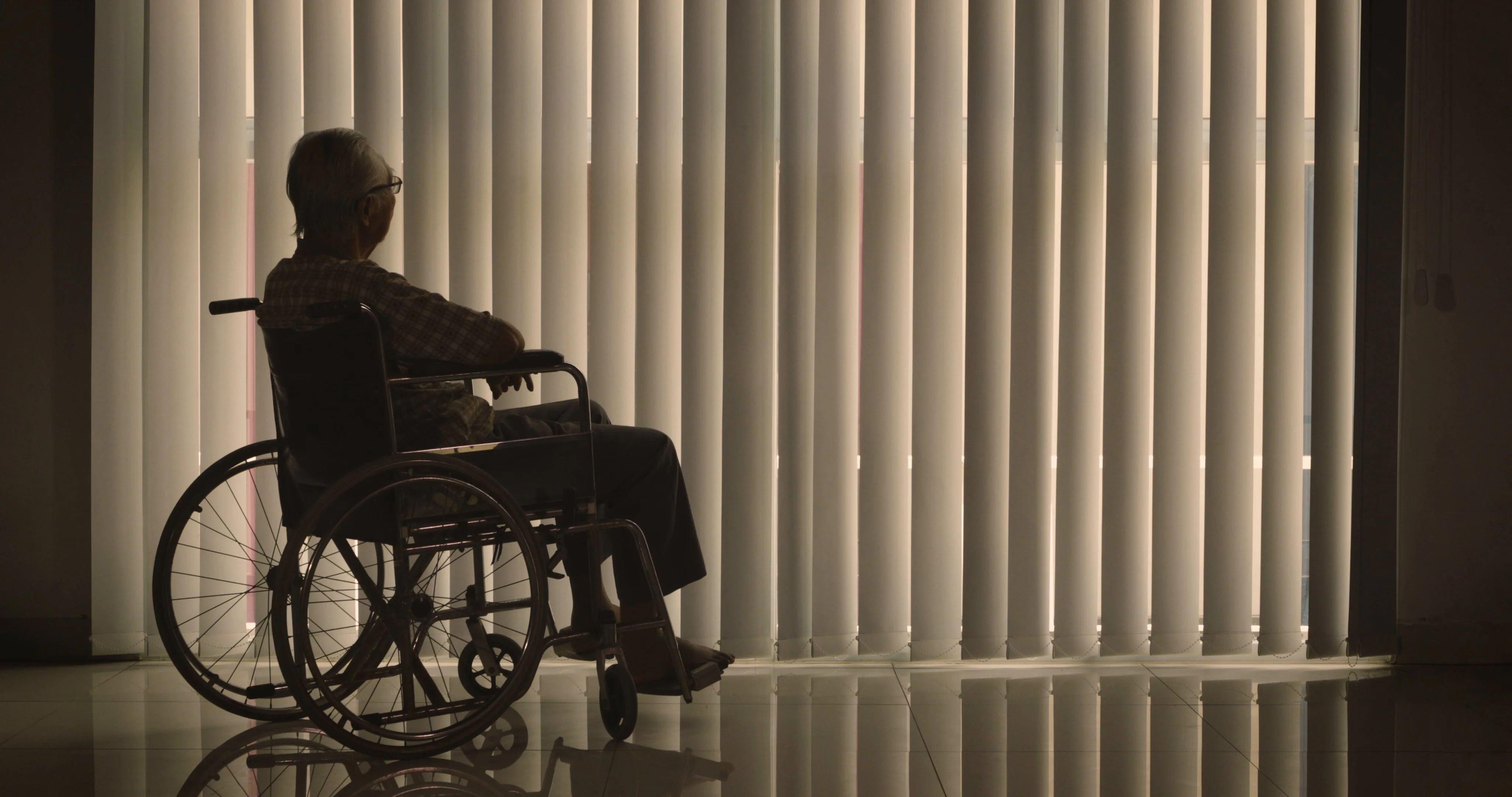 Elderly Man In Wheelchair Looking At Camera With A Blank Stare