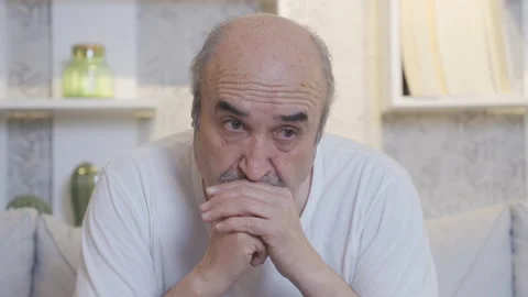 Old man sitting alone on sofa at home and thinking seriously. Stock-Footage 225599839