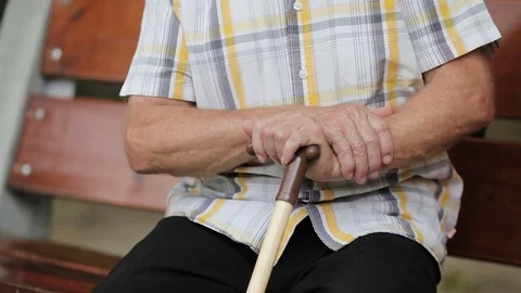 Old man sitting on a bench in park Stock Footage 80436996
