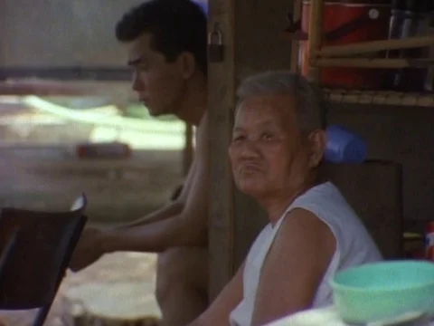 Old man sitting peacefully and woman climbing a step Stock Footage 79925845