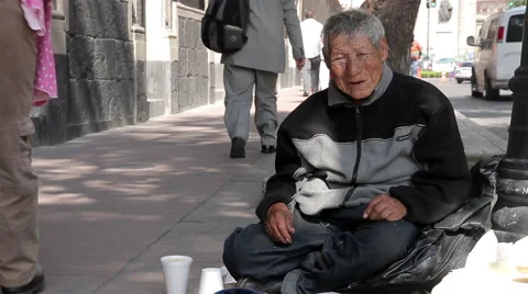 Old man sitting in the sidewalk. Mexico City, Mexico. FULL SHOT-HANDHELD SHOT. Stock Footage 42575255