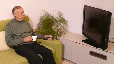 Old man sitting on the sofa and watching tv Stock Footage 71893791