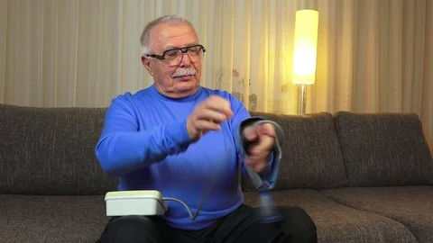 Old man sitting on sofa enjoys measured good pressure Stock Footage 108130744