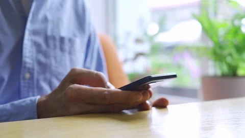 Old man sitting at a table using her mobile phone. Stock Footage 291920004