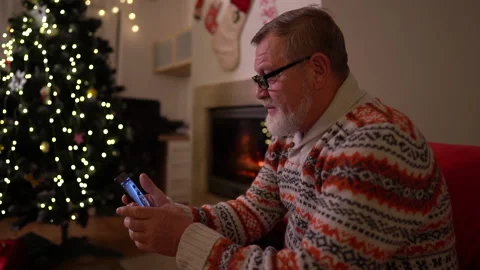The old man with a smartphone make a video call his family near the christmas Vídeo Stock 143411899
