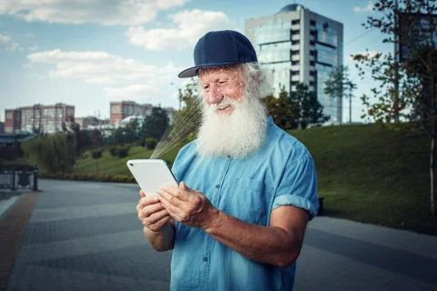 Old man with smartphone using face ID recognition system.Biometric Stock Photos
