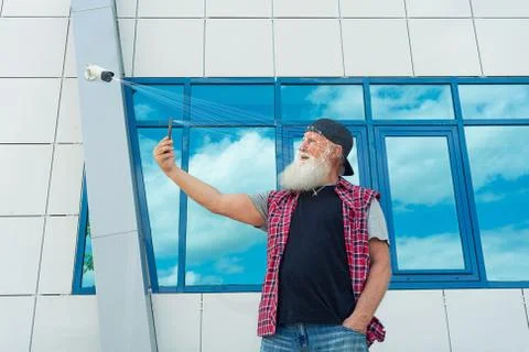 Old man with smartphone using face ID recognition system.Biometric Stock Photos