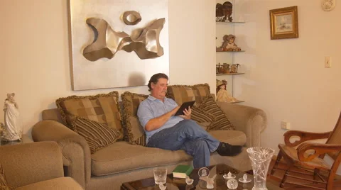 Old man in sofa with Ipad-tablet computer Stock Footage 50880002
