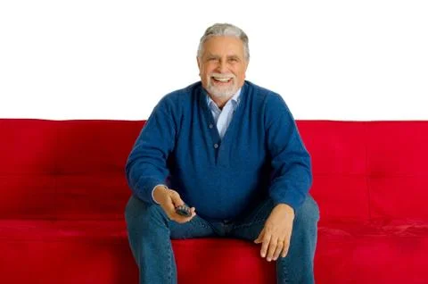 Old man on the sofa with television remote control Stock Photos