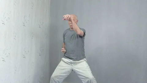 Old man in sportswear performs blocks with his hands Stock Footage 149755117