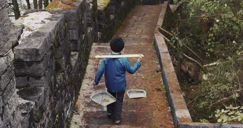 A old man, stone building worker walking on the southern great wall of china in Stock Footage 201096671