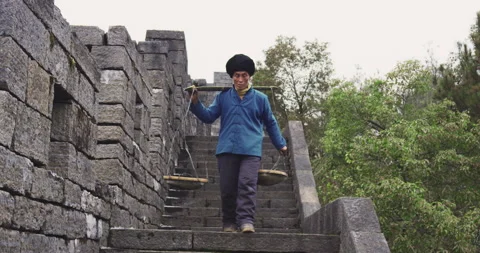 A old man, stone building worker walking on the southern great wall of china in Video stock 201096790