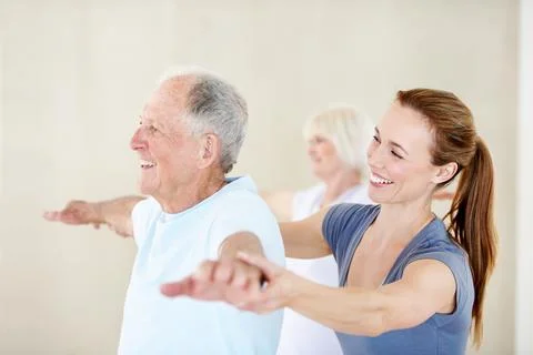Old man, stretching and exercise with personal trainer in gym, smile or phy.. Stock Photos