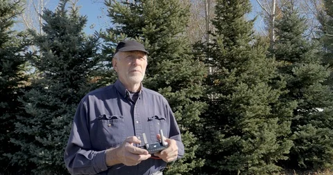 Old man stubbly gray beard flying drone-C4K 10bit 422 Stock Footage 98608011
