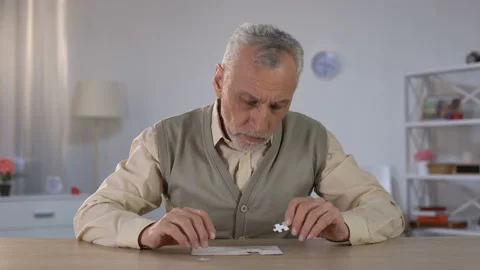 Old man successfully combining puzzle, exercise to improve cognitive function Stock Footage 108132322