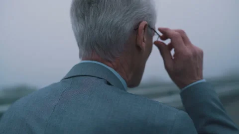 An old man in a suit walks in cloudy weather Stock Footage 144576541