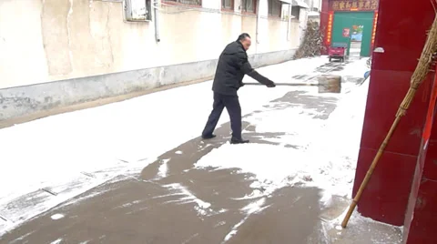 Old man sweeps the snow on the road Stock Footage 34882730