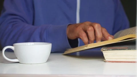 Old man swipes down and turns over book page slow motion Stock Footage 119596549