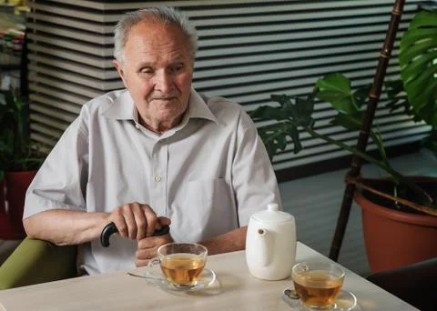 Old man  at the table. Stock Photos