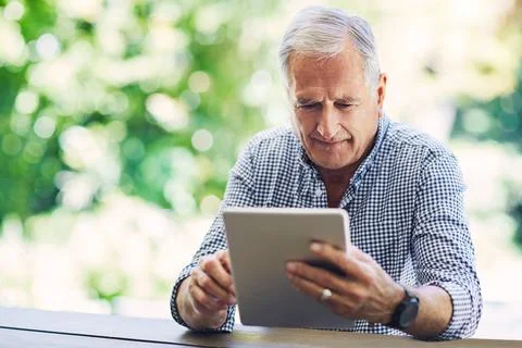 Old man, tablet and scroll in backyard with reading, space and edit digital.. Stock-Fotos