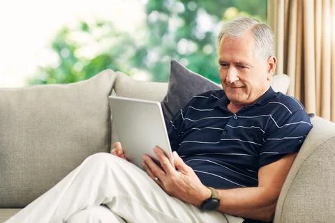 Old man, tablet and scroll on couch with reading, story or editing digital .. Stock-Fotos
