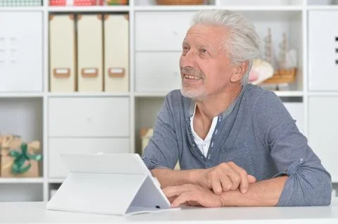 Old man with tablet computer at home Stock Photos