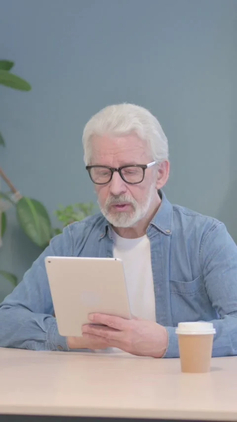 Old Man Talking for Online Video Chat via Tablet Computer, vertical video Stock Footage 329106650