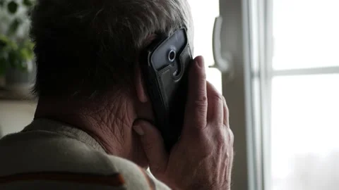 Old man talking on the phone, hand holding the phone 4K Stock Footage 147067133