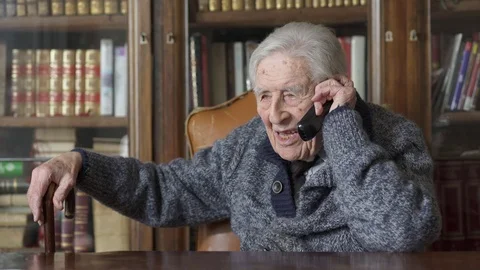 Old man talks on mobile phone at home Video stock 74720869