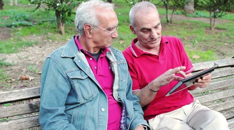 Old man teaching his elderly friends to use a new tablet PC 動画素材 32357604
