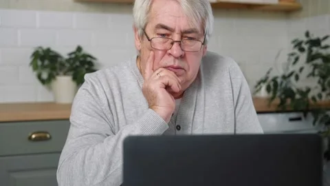 Old man Thinking at Laptop. Aged Man Sitting at Table with laptop. Stock Footage 231858650