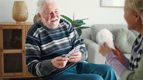 Old man throws the winning card and ends the cards game laughing Stock Footage 172350853