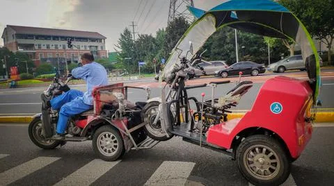 Old man on Tricycle pulling broken tuk-tuk outdoor, Shanghai, China Stock Photos
